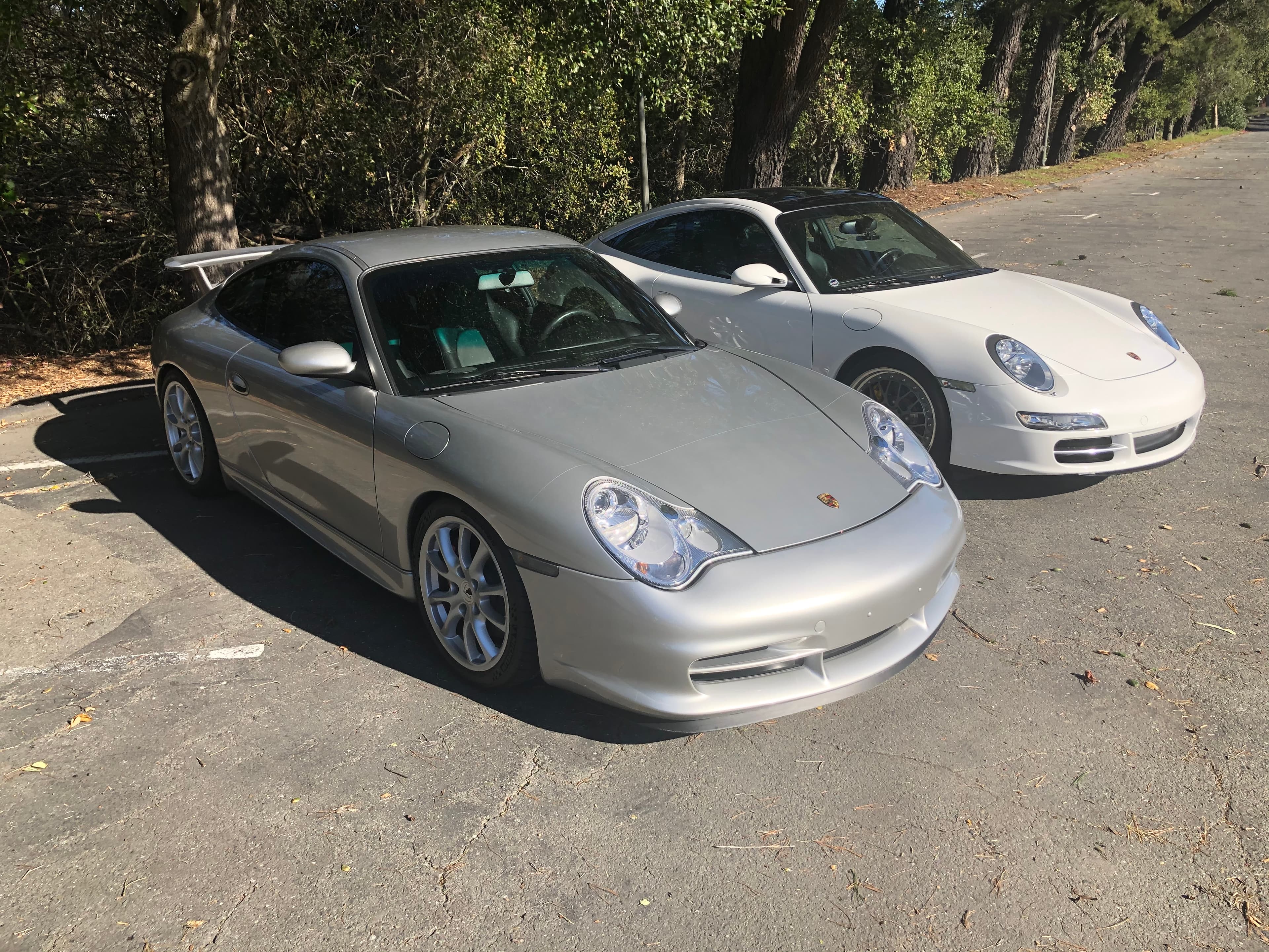 Matthew Herman’s silver 996.2 GT3 at a parking-lot meet, nose and taco wing, with a white 997 behind